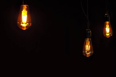 Siyah arka planda sarı ampul. Metin ve tasarım için boşluk. Ampulün yanına uzayı kopyala. Model