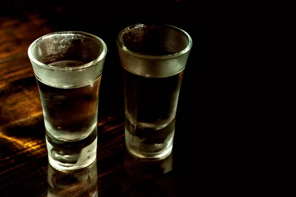 Két Befagyott Pohár Közeledik Szemüveg Alkohollal Egy Fekete Asztalon Vodka — Stock Fotó