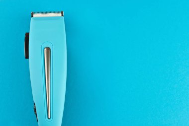 Mavi arka planda saç makasıyla izole edilmiş. Kuaför aletini kapat. Boşluğu ve yeri metin için kopyala. Tasarım için tasarım. Model.