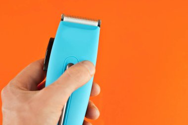 Saç makasi yakin. Turuncu arka planda mavi kuaför aleti. Tasarım için düzenName.