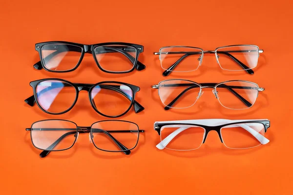Διαφορετικοί Τύποι Γυαλιών Πορτοκαλί Φόντο Από Κοντά Γυαλιά Ορθογώνια Και — Φωτογραφία Αρχείου