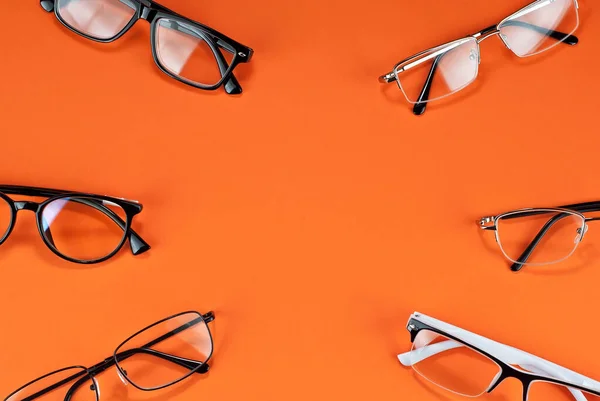 Různé Typy Brýlí Oranžovém Pozadí Zblízka Sklenice Obdélníkovými Kulatými Rámy — Stock fotografie