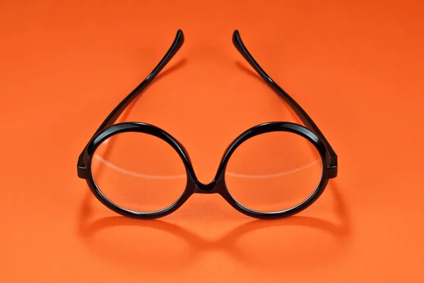 オレンジの背景に異なるタイプのガラスが閉じます 丸枠のメガネ — ストック写真