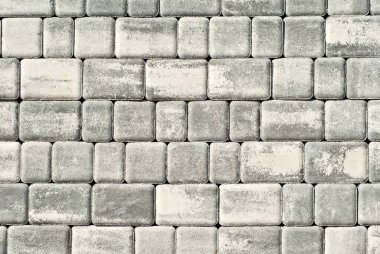 Çakıl taşı dokusu. Kaldırımdaki fayanslar eşit katlanmış. Gri kaldırım taşları kapanır.