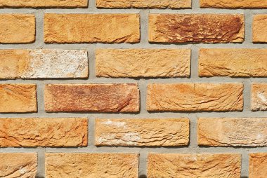 Tuğla duvar dokusu. Yeni tuğla işi. Sergilerde duvar veya çit örnekleri sunuluyor. Turuncu tuğla yakın çekim.