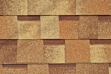 Esnek kiremit ziftle kaplanmış fiberglastan yapılır. Turuncu çatının dokusu yakın..