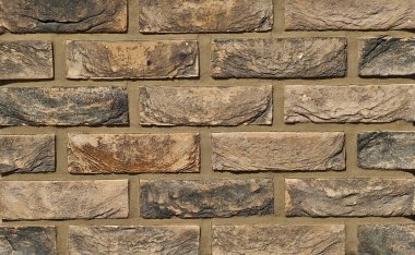 Tuğla duvar çıkıntısı. Yeni tuğla işi. Sergilerde duvar veya çit örnekleri sunuluyor. Kahverengi tuğla yakın çekim.