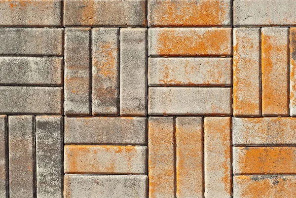 Cobblestone texture. The sidewalk tile is evenly folded. Brown and orange cobblestones close up.