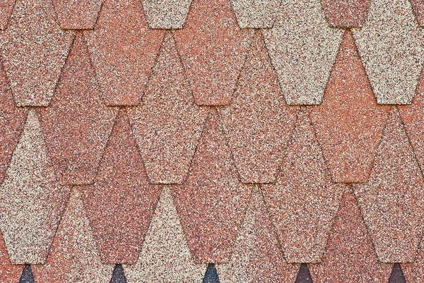 Flexible tile is made of fiberglass impregnated with bitumen. Texture of orange roof close up.