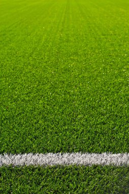 Futbol sahası dokusu yakın. Stadyumda ot var. Spor sahaları için iyi biçilmiş çimenler. Düz çizgiler beyaz boyayla çizilir. Stadyumdaki kısıtlı bölgeler.