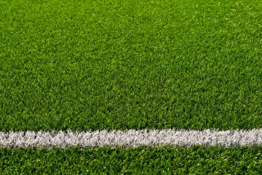 Futbol sahası dokusu yakın. Stadyumda ot var. Spor sahaları için iyi biçilmiş çimenler. Düz çizgiler beyaz boyayla çizilir. Stadyumdaki kısıtlı bölgeler.