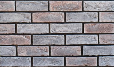 Tuğla duvar dokusu. Yeni tuğla işi. Sergilerde duvar veya çit örnekleri sunuluyor. Mor tuğla yakın çekim.