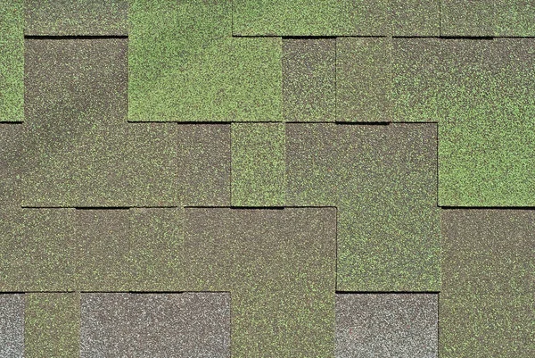 Flexible tile is made of fiberglass impregnated with bitumen. Green roof texture close up.