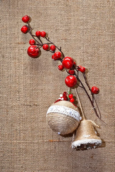 Christmas decorations from natural materials. Multicolored garlands and toys close up. Natural jewelry hangs on linen fabric. Fabric texture in the background.