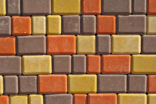 Cobblestone texture. The sidewalk tile is evenly folded. Brown, yellow and orange cobblestones close up.