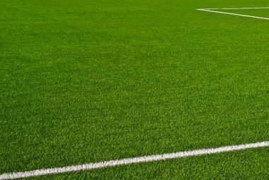 Futbol sahası dokusu yakın. Stadyumda ot var. Spor sahaları için iyi biçilmiş çimenler. Düz çizgiler beyaz boyayla çizilir. Stadyumdaki kısıtlı bölgeler.