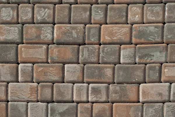 Cobblestone texture. The sidewalk tile is evenly folded. Brown cobblestones close up.