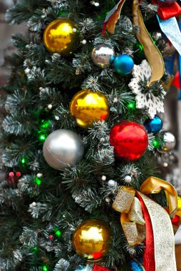 Geleneksel Noel süsleri Noel ağacında. Çok renkli çelenkler ve oyuncaklar kapanıyor.