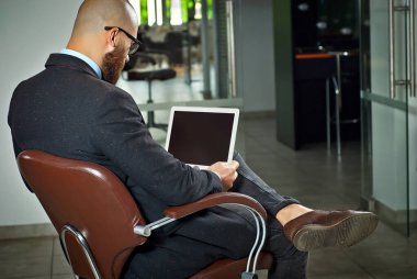 Kahverengi deri sandalyede oturan mavi gömlekli bir iş adamı. Gözlüklü dizüstü bilgisayarı olan ceketli bir adam. Sakallı ofis çalışanı..