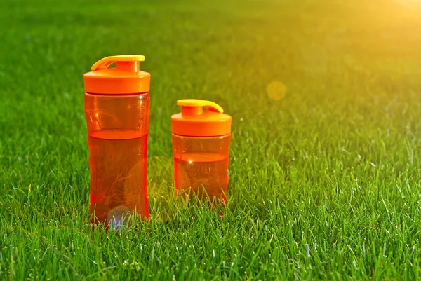 Oranje Fles Met Water Groen Gras Het Concept Van Een — Stockfoto