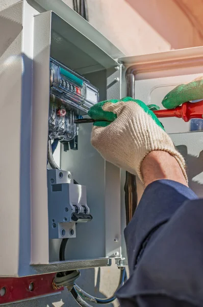 A person working on the installation of electrical meter equipment .