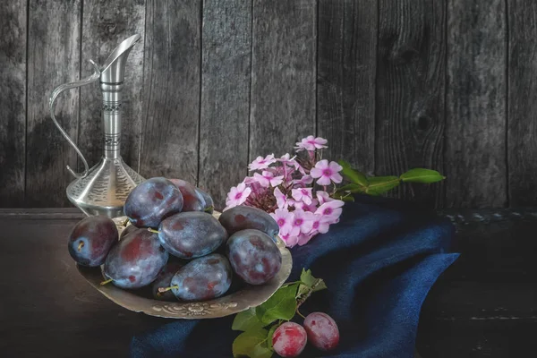 Ripe and juicy blue plums in a wicker basket in a rustic style. Happy Thanksgiving. Copy space. The horizontal frame.