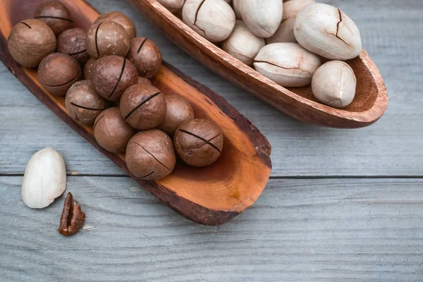 Pecan and macadamia nuts on wooden background. Copy space.