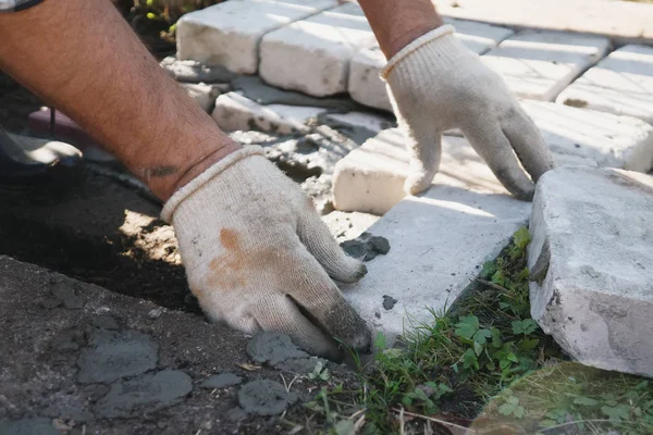 working hands lay brick masonry in cement mortar.