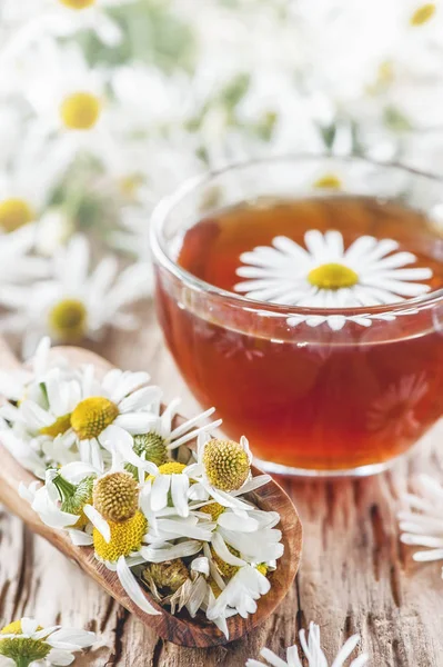 A clear Cup of medicinal chamomile tea on an old wooden table. Health and healthy lifestyle concept.