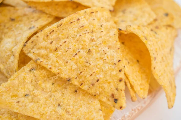 Background of corn tortillas or Nachos fried on open fire. Copy space. Close up.