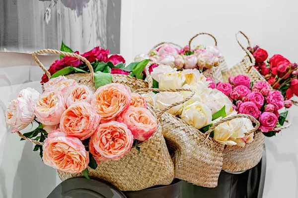 Exotic roses from pink elite modern varieties in a bouquet in a basket as a gift. English elite varieties of roses.