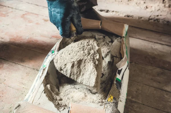 Cement powder in the cement bag, a hand hold the trowel scoop cement powder cray for construction work