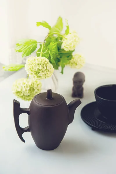 Cup of tea with white flowers on a light background. Mocap for postcards. Spring. beautiful teapot. A copy of the space. the concept of holidays and wishes of good morning.