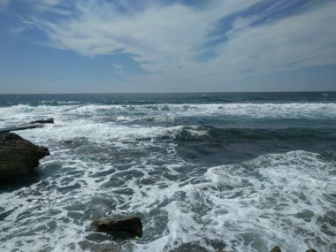 Küçük dalgalar ve mavi gökyüzü ile deniz manzarası.