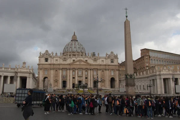 游客和圣彼得大教堂的主要立面在圣彼得广场与雨云的背景，梵蒂冈城州，意大利. — 图库照片