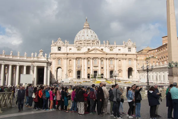 Touristes et façade principale de la basilique Saint-Pierre sur la place Saint-Pierre avec des nuages pluvieux en arrière-plan, État de la Cité du Vatican, Italie . — Photo