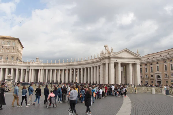 Turisták és oszlopsor a Szent Péter téren a háttérben esős Felhőkkel, Vatikáni Városállam, Olaszország. — Stock Fotó