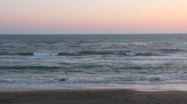 Küçük dalgalar ve arka planda gün batımı ile Seascape.