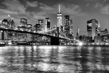 New York City, financial district in lower Manhattan with Brooklin Bridge at night, USA. BW clipart