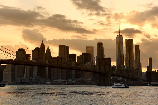 New York cityscape at sunset. New York City, financial district in lower Manhattan view from Brooklyn Bridge Park.