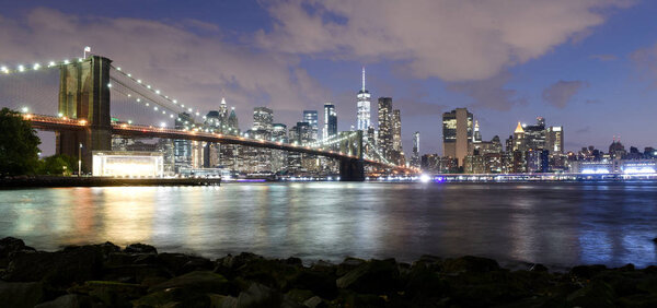 New York City, financial district in lower Manhattan with Brooklin Bridge at night, USA