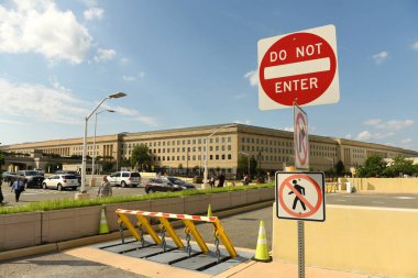 Washington, DC - June 01, 2018: Safety barriers and stop sign in front of Pentagon building, headquarters for the United States Department of Defense. clipart