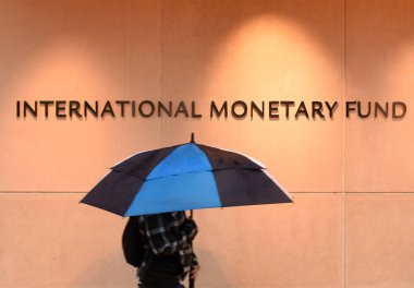 Washington, DC - June 04, 2018: Pedestrian with an umbrella near International Monetary Fund, IMF Headquarters 2 Building (HQ2) in DC. clipart