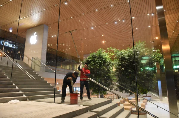 Trabajadores lavan ventanas en la tienda Apple en Michigan Avenue en Chicago por la noche . — Foto de Stock