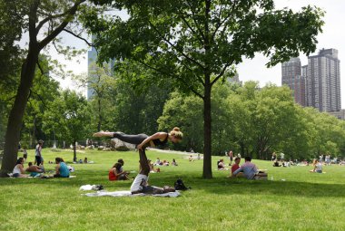 New York, ABD - 26 Mayıs 2018: İnsanlar New York'taki Central Park'ta çayır üzerinde sakin ol.