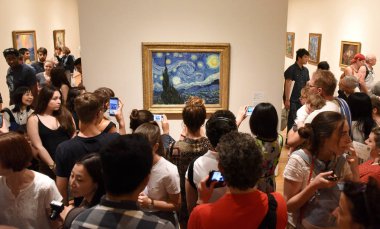 New York, Amerika Birleşik Devletleri - 25 Mayıs 2018: Kalabalık içinde Modern Sanat Müzesi New York'ta boyama Vincent van Gogh yıldızlı gece yakın kişi.