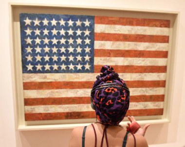 New York, ABD - 8 Haziran 2018: Ziyaretçi görünüyor 'Bayrak' sanatçı Jasper Jones tarafından Modern Sanatlar Müzesi (Moma) New York'ta işyerinde.
