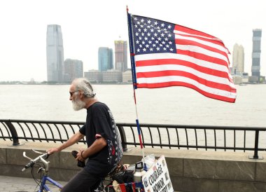 New York, Amerika Birleşik Devletleri - 28 Mayıs 2018: Bir adam bizimle New York Battery Park City Esplanade bir bisiklet bayrağı.