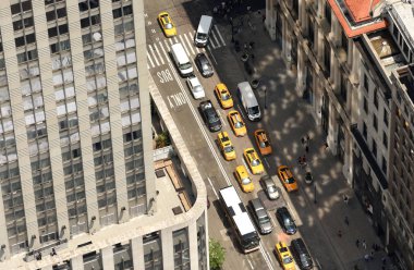 New York City sokaklarında gökdelenler üzerinden görüntüleyin. Yolda araba ile üstten görünüm sokakta. New York'ta sarı taksi taksi