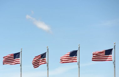 Mavi gökyüzünde sallanan Amerikan bayrakları